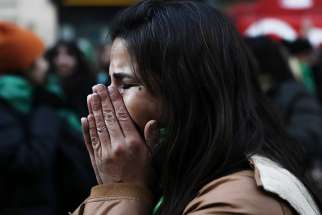 A woman in Buenos Aires, Argentina, reacts June 14 after hearing that the nation&#039;s lower house approved a bill to legalize abortion in the first 14 weeks of pregnancy. 