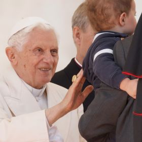 Pope Benedict XVI has asked an Italian married couple, founders of the Focolare Movement&#039;s New Families initiative, to write the meditations for his Way of the Cross service at Rome&#039;s Colosseum April 6. He is pictured greeting a child during his general audience in St. Peter&#039;s Square at the Vatican March 14.