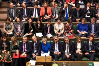 British Prime Minister Theresa May, center in blue, reacts during a no-confidence debate Jan. 16, a day after Parliament rejected her Brexit deal in London. 