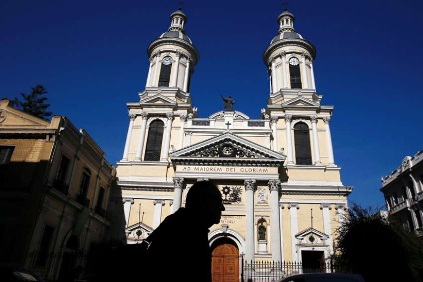 A man is silhouetted in front of St. Ignatius of Loyola Church in Santiago, Chile June 13, 2018. Pope Francis praised the opening of the Center for Investigation of Abuse and Early Prevention at the Pontifical Catholic University of Chile in an Aug. 15, 2019, video for the occasion.