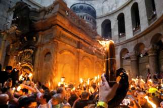 Orthodox Christian worshippers hold candles around what is believed to be the tomb of Christ during the ancient Eastern rite ceremony of the Holy Fire in the Church of the Holy Sepulcher in Jerusalem&#039;s Old City, April 15, 2023.