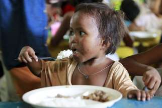 A boy eats a free meal during a July 20 feeding program at a slum area in Manila, Philippines. The head of the Philippine bishops&#039; conference said helping the poor and getting rid of political dynasties should be front and center in the months leading up to the country&#039;s May elections. 