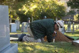 A church employee at St. Mary Catholic Church in Alexandria, Va., prepares an urn burial at the parish&#039;s cemetery in this 2017 file photo.
