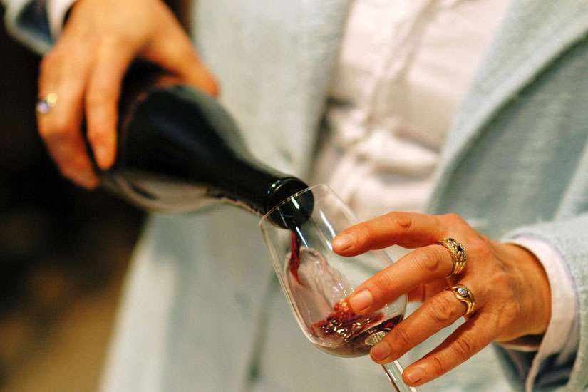 A bottle of red wine being poured. Pope Francis says that wine expresses the abundance of a wedding and the joy of the celebration.