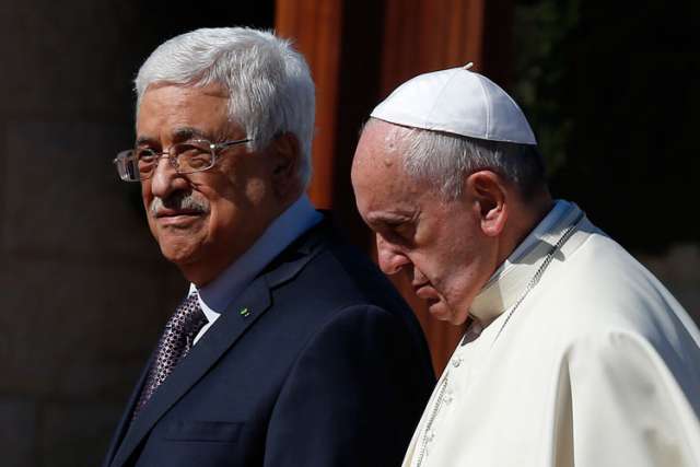 Pope Francis walks with Palestinian President Mahmoud Abbas during an arrival ceremony at the presidential palace in Bethlehem, West Bank, May 25.