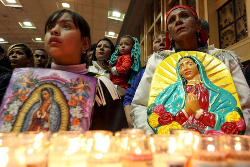 Pilgrims hold up images of Our Lady of Guadalupe during an annual pilgrimage in her honor at the cathedral in Ciudad Juarez, Mexico, Dec. 11. 