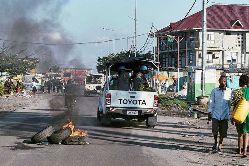 Peacekeepers drive past burning tires as they patrol Kinshasa, Democratic Republic of Congo, April 10. Violence in southern Congo has left more than 3,300 people dead since October, according to a report by Catholic officials June 20. 
