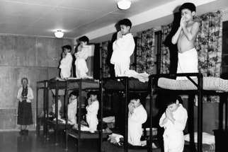 Indigenous boys pray on bunk beds in a dormitory at the Bishop Horden Memorial School, a residential school in Moose Factory, Ont., in 1950.