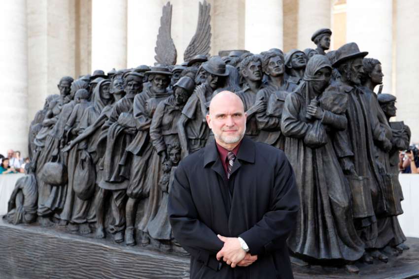 Sculptor Timothy P. Schmalz poses with his statue after Pope Francis celebrated a Mass for the World Day of Migrants and Refugees in St. Peter&#039;s Square at the Vatican Sept. 29, 2019.