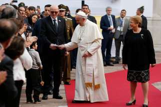 Pope Francis walks with Chilean President Michelle Bachelet after arriving for a meeting with government authorities, members of civil society and the diplomatic corps Jan. 16 at La Moneda presidential palace in Santiago.