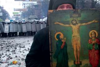 A clergyman holds a religious picture during a rally by pro-European Union protesters in Kiev, Ukraine. Ukrainians are finding it hard to understand why the world is paying so little attention to the conflict in Ukraine.
