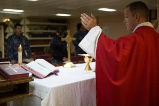 Father William J. Brunner, of the Diocese of Green Bay, Wis., celebrates Mass in May aboard the Navy warship USS America docked in San Diego. Father Brunner, who holds the rank of lieutenant, is one of the Navy&#039;s newest chaplains