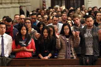 People recite the Lord&#039;s Prayer during a Mass for young adults Dec. 7 at St. Patrick&#039;s Cathedral in New York City.