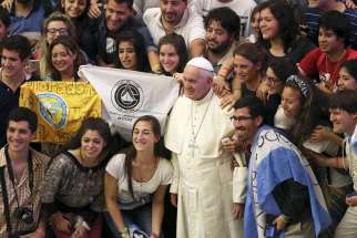 Pope Francis poses for a photo with Argentine youths during his weekly audience in Paul VI hall at the Vatican Aug. 19.