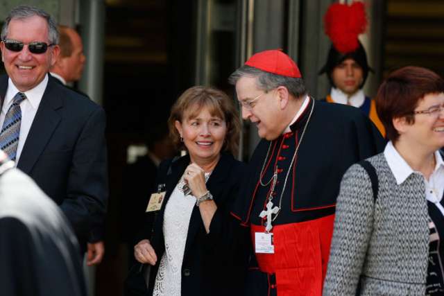 .S. Cardinal Raymond L. Burke, prefect of the Supreme Court of the Apostolic Signature, walks with Alice and Jeff Heinzen of Menomonie, Wis., as they leave the morning session of the extraordinary Synod of Bishops on the family at the Vatican Oct. 9. Th e couple are auditors at the synod. 