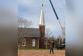 Fr. Peter Wojakiewicz, pastor of St. Martin of Tours Parish in Cumberland, PEI, is on hand for the raising of the church’s new steeple. The original was damaged by a 2022 tropical storm.