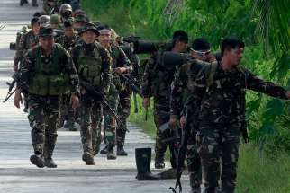 Government forces of the Philippines patrol a street in Pigcawayan June 22. 