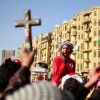 A demonstrator holds up a crucifix and a Quran during a protest at Tahrir square in Cairo. Religious communities can help pro-democracy movements in the Middle East and North Africa by upholding human dignity, says a Vatican official.