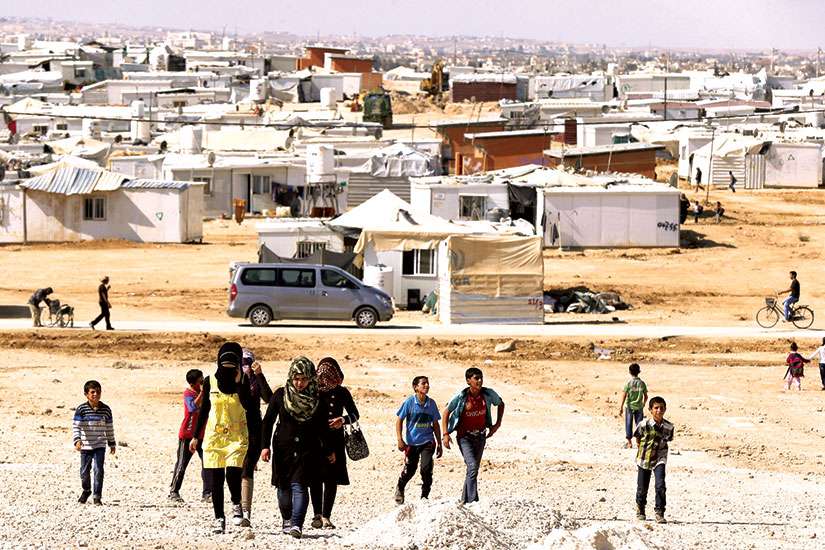 Syrian refugees walk at Zaatari refugee camp in the Jordanian city of Mafraq, near the border with Syria. Catholic Crosscultural Services has teamed with the federal government to try and link Syrian refugees with family and sponsors in Canada.
