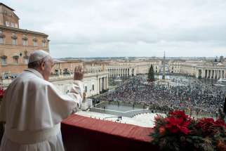 Pope Francis greets the crowd as he leads his Christmas message and blessing &quot;urbi et orbi&quot; (to the city and the world) from the central balcony of St. Peter&#039;s Basilica at the Vatican Dec. 25, 2021.