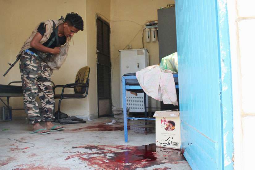 A pro-government militant inspects a room filled with blood after it was attacked by gunmen in Aden, Yemen, March 4. 