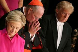 Democratic presidential nominee Hillary Clinton, Archbishop of New York Cardinal Timothy Dolan, and Republican presidential nominee Donald Trump pray as they attend the Alfred E. Smith Memorial Foundation dinner to benefit Catholic charities in New York. October 20, 2016.
