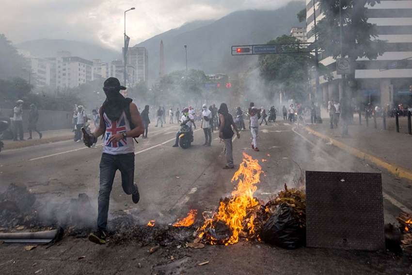 A group of people protest during an opposition march April 22 in Caracas, Venezuela. In response to a renewed constitutional crisis in the country, the Venezuelan bishops&#039; conference has called for &quot;peaceful civil disobedience&quot; to restore constitutional order.