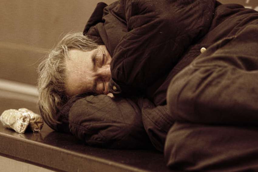 A homeless man sleeps in the street. Church on the Street is an outreach program that provides a listening presence for those who have felt life&#039;s hurts. 