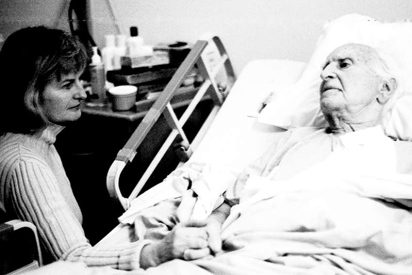 A Toronto woman praying with her 92-year-old father at Riverdale Hospital in 2004.