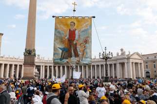 A man holds a banner showing new St. Nunzio Sulprizio during the canonization Mass for seven new saints celebrated by Pope Francis in St. Peter&#039;s Square at the Vatican Oct. 14. Among the new saints were St. Paul VI and St. Oscar Romero. 