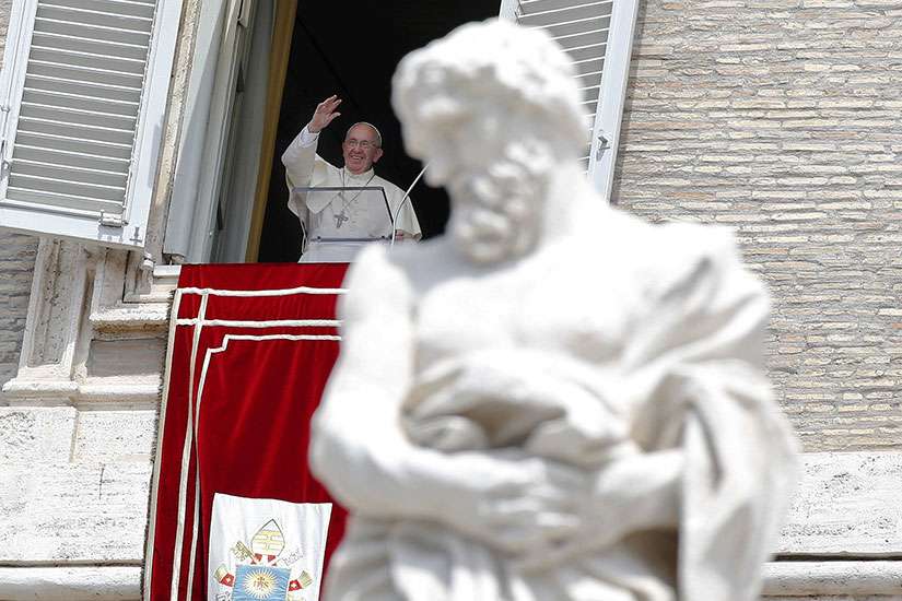Pope Francis waves as he leads the Angelus from the window of his studio overlooking St. Peter&#039;s Square at the Vatican Aug. 2.