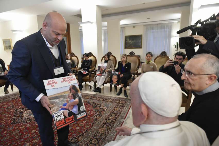 Pope Francis meets relatives of hostages taken by Hamas militants from Israel Oct. 7 in his residence, the Domus Sanctae Marthae, at the Vatican Nov. 22, 2023. Members of the delegation carried posters of their loved ones.