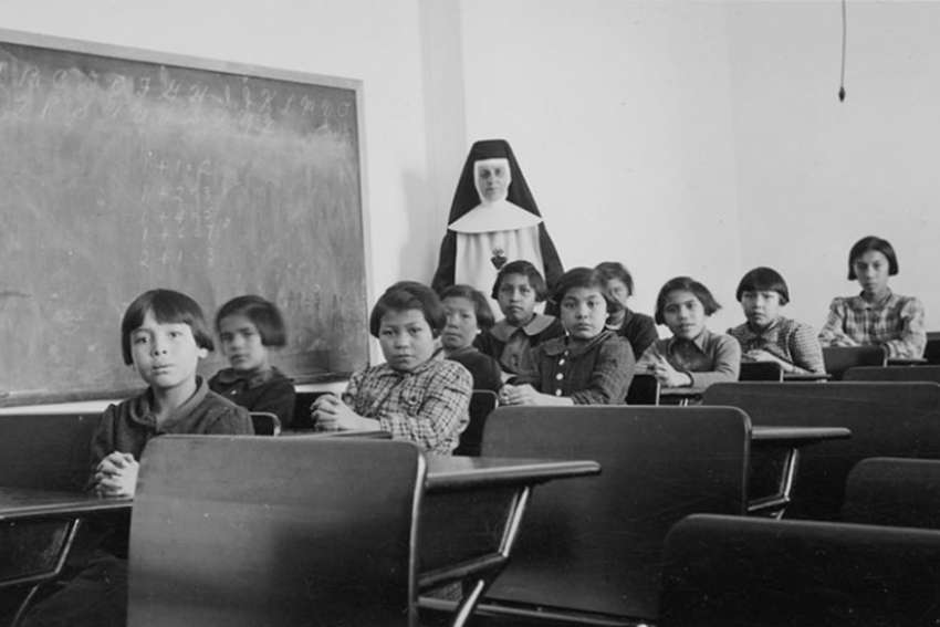 Students at Cross Lake Indian Residential School in Manitoba pose with their teacher in 1940.