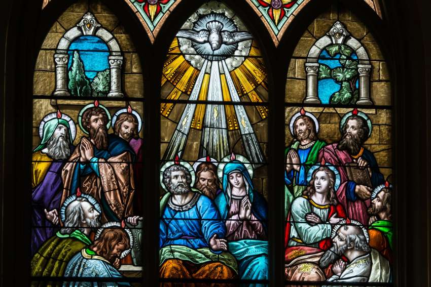 A stained glass window at St. Mary Church in Luxemburg, Wis., depicts the Holy Spirit descending upon the Apostles at Pentecost.
