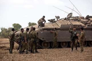 Israeli soldiers meet July 25 after ending their duty inside the Gaza Strip, on the Israeli side of the border.