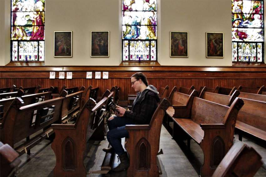 A woman reads a prayer book in the sanctuary of St. Mary Church in Appleton, Wis.