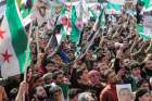 People carry banners and opposition flags during a demonstration marking the 10th anniversary of the start of the Syrian conflict, in the opposition-held city of Idlib, Syria, March 15, 2021. As Syria marks 10 years of devastating conflict, the country is in economic and social shambles with millions of people displaced and millions more living below the poverty line.