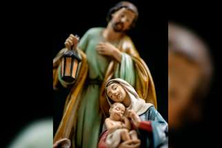 Mary, Joseph and the baby Jesus are depicted in a wooden creche