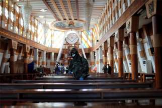 A member of the civil defense team disinfects inside Our Lady of Salvation Church in Baghdad, Iraq, Dec. 30, 2020, during the COVID-19 pandemic. Pope Francis plans to visit Iraq March 5-8.