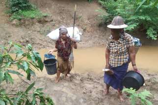 Villagers displaced by fighting in eastern Myanmar cross a river in Kayah state June 12, 2021. Myanmar&#039;s military has arrested seven workers from the Catholic Church&#039;s social arm Caritas (Karuna) who were on a mission to provide aid for internally displaced persons in Kayah.