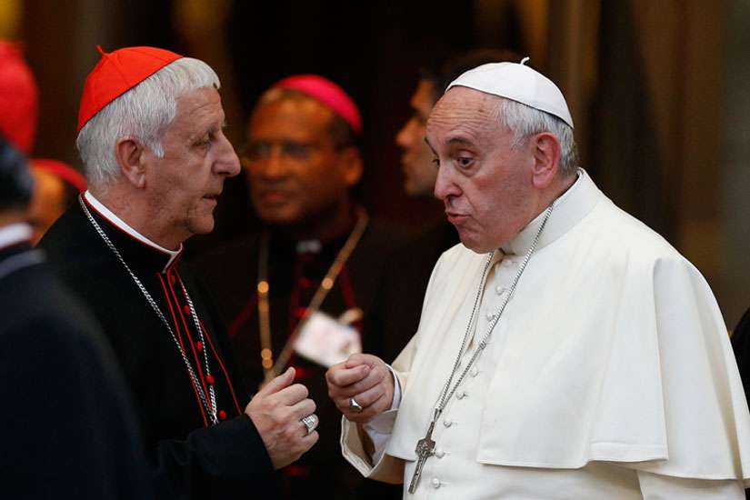 Pope Francis talks with Italian Cardinal Giuseppe Versaldi as they leave the concluding session of the extraordinary Synod of Bishops on the family at the Vatican Oct. 18. 