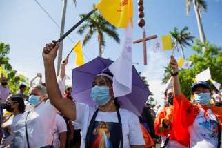 Pilgrims hold flags as they participate in a Marian event in the atrium of the Metropolitan Cathedral in Managua, Nicaragua, Aug. 13, 2022, after police banned a Catholic procession and pilgrimage in the capital, citing security reasons.