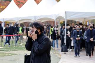 A person mourns at a group memorial Oct. 31, 2022, for the victims an Oct. 29 stampede that killed more than 150 people during a Halloween festival in Seoul, South Korea.