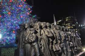 Timothy Schmalz’s Angels Unawares is unveiled Dec. 8 in front of the  public Christmas tree put up by the Diocese of Brooklyn, N.Y., at Grand Army Plaza.