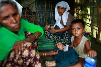 Displaced Myanmar residents sit inside a shelter at a camp outside Sittwe, Myanmar, June 18.