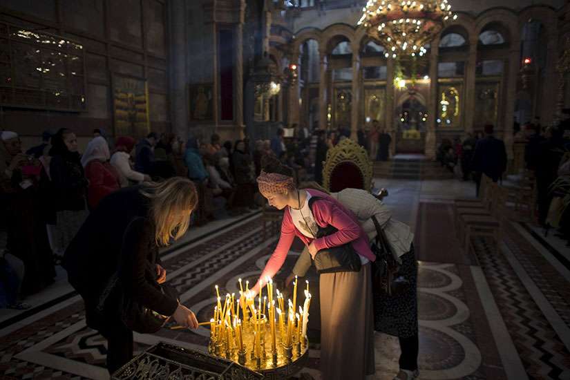 Women light candles in the Church of the Holy Sepulcher in Jerusalem&#039;s Old City April 5, Easter Sunday.