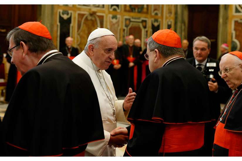 Pope Francis greets U.S. Cardinal Raymond L. Burke, patron of the Knights and Dames of Malta, during an audience to exchange Christmas greetings with members of the Roman Curia in Clementine Hall at the Vatican Dec. 22. 