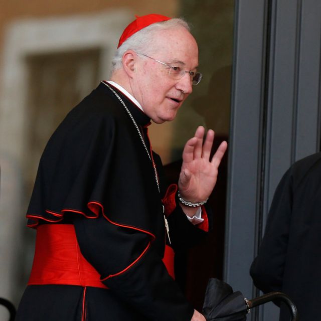 Cardinal Marc Ouellet, prefect of the Congregation for Bishops, center, waves as he arrives for the fourth day of general congregation meetings in the synod hall at the Vatican March 7.