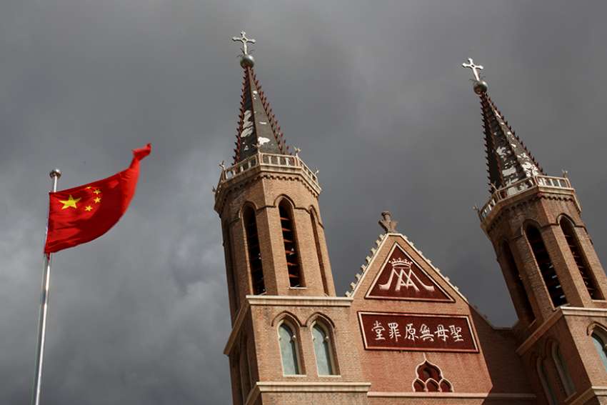 The Chinese national flag flies in front of a Catholic church in Huangtugang, China, in this 2018 photo. As the Vatican-China agreement on the naming of bishops approaches two years, Beijing is still lagging behind in giving concessions compared with those made ahead of the deal by the Vatican.
