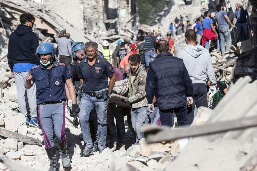 Rescuers carry an injured man in Amatrice, Italy, following an earthquake Aug. 24.